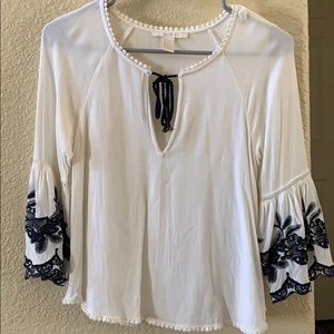 White top with bell sleeves & navy blue embroidery